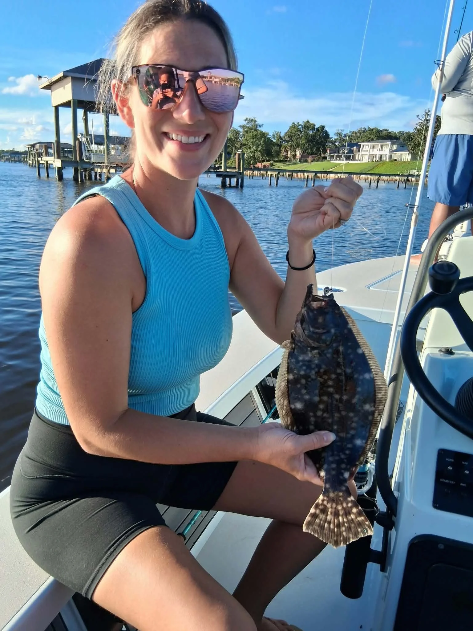Woman holding flounder she caught using limit out lures 3-inch paddle tail swimbait 