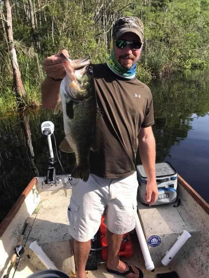 Customer holding a nice bass, he caught with straight worm.