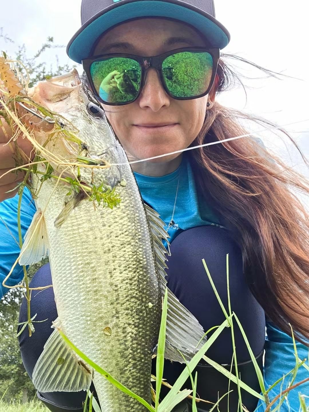 angler holding Bass caught on 3 inch hellgrammite from limit out lures 
