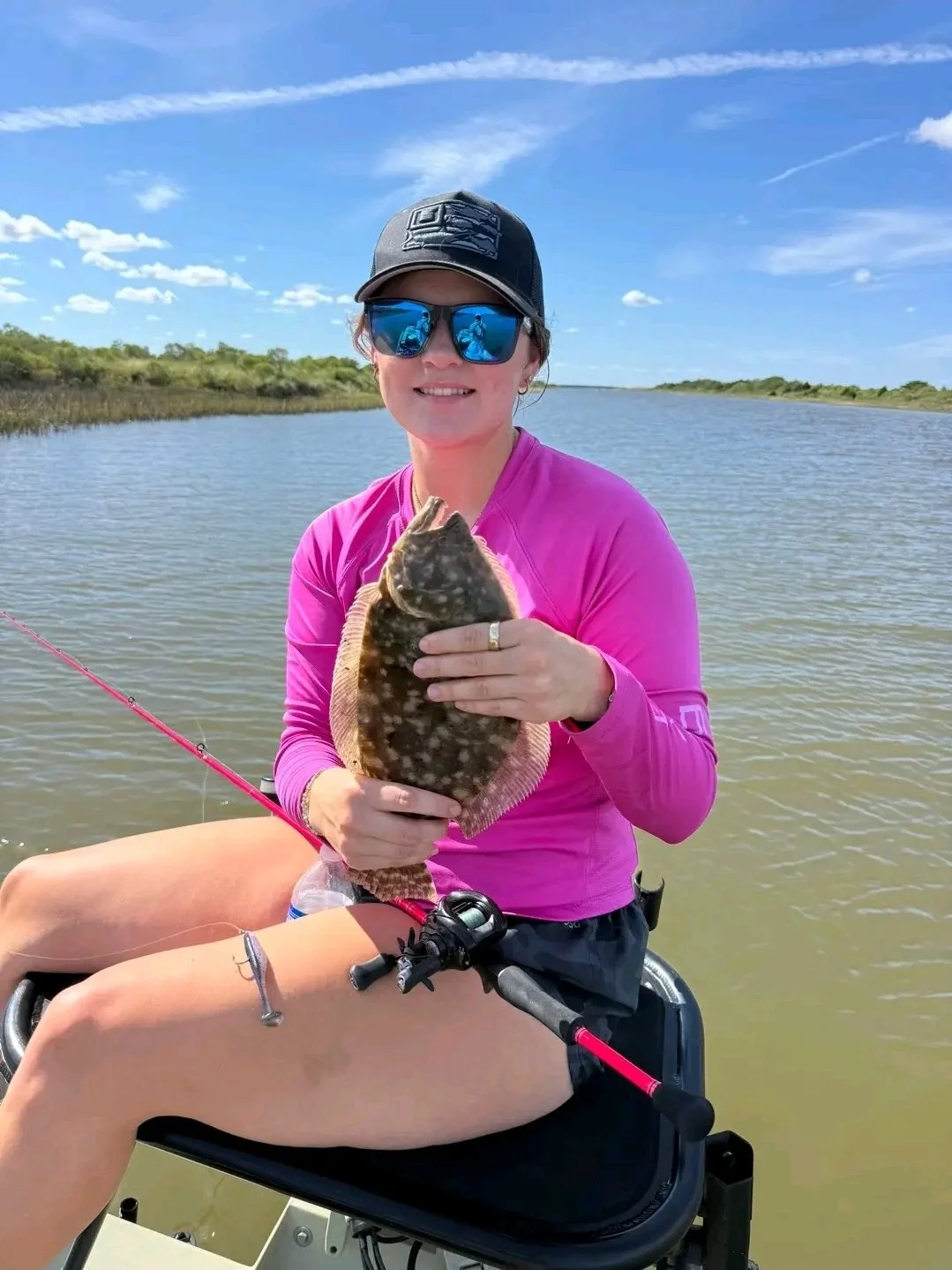 woman angler inshore fishing the flats with limit out lures artificial bit catching and holding a flounder. 