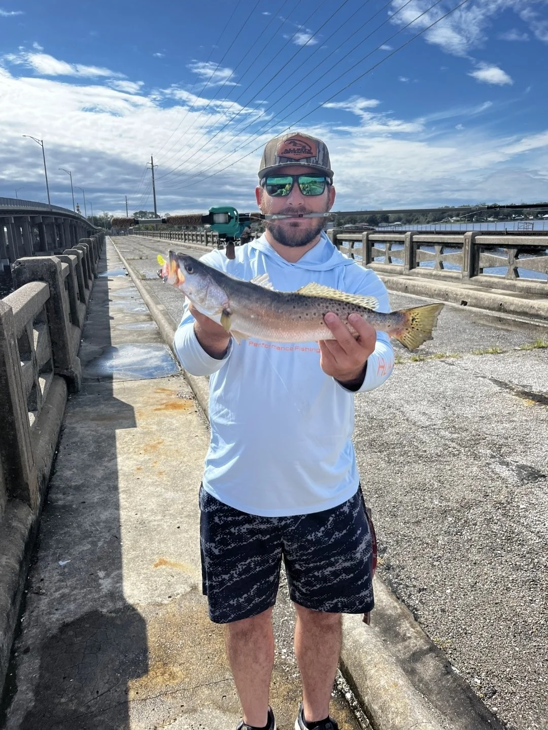 angler fishing from pier holding trout he caught using the 3.8 limit out lures avenger paddletail