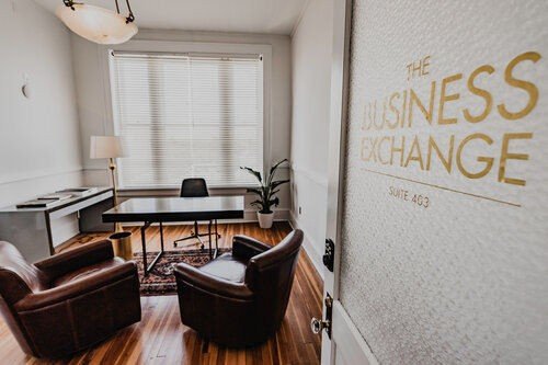 A private office rental with a desk, leather chairs at The Business Exchange in Thomasville, GA