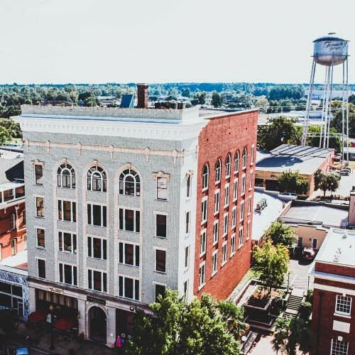 High-angle view of the historic 5-story white and red brick Upchurch Building in Thomasville, GA