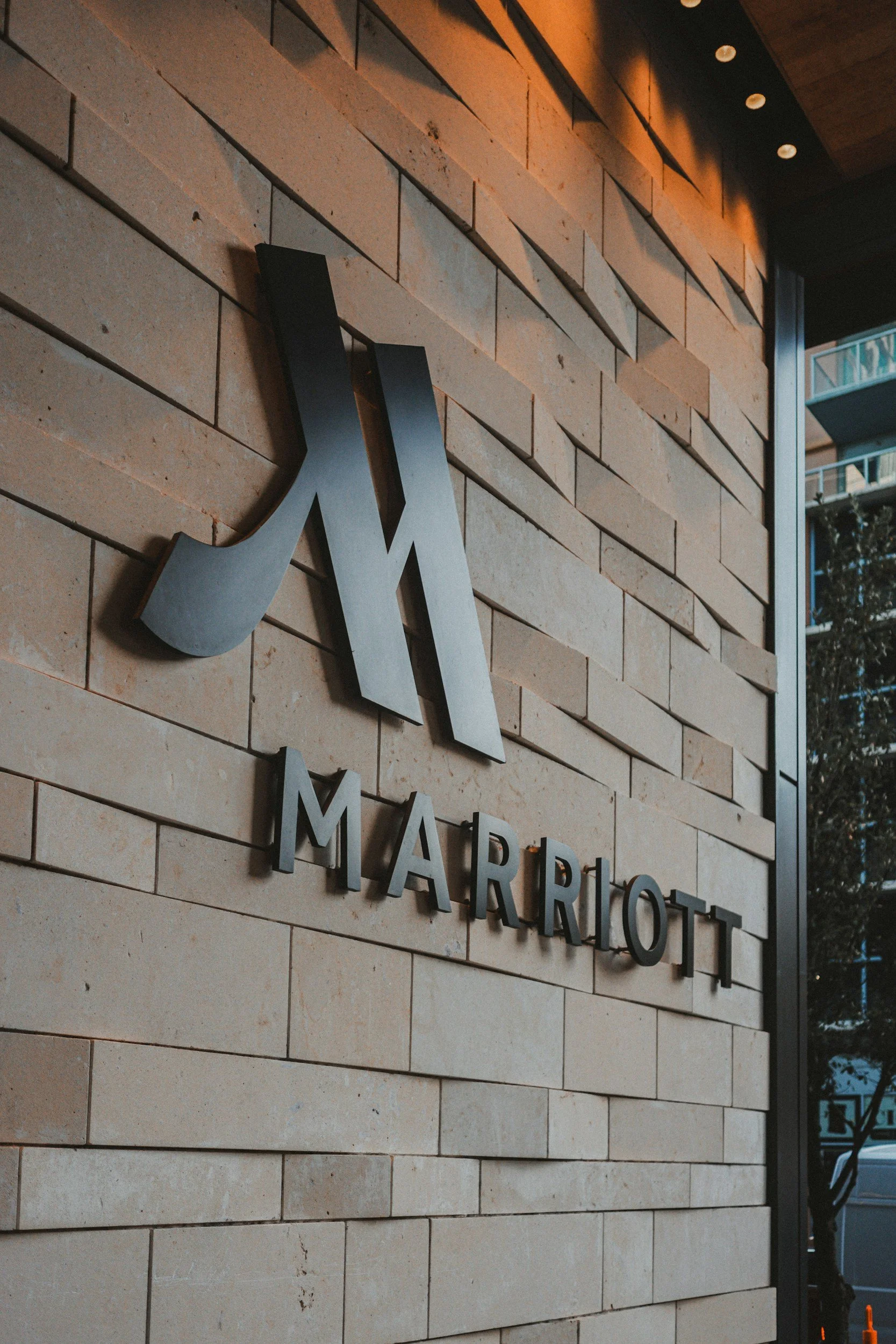 Close-up of a sign for Marriott hotel mounted on a beige brick wall