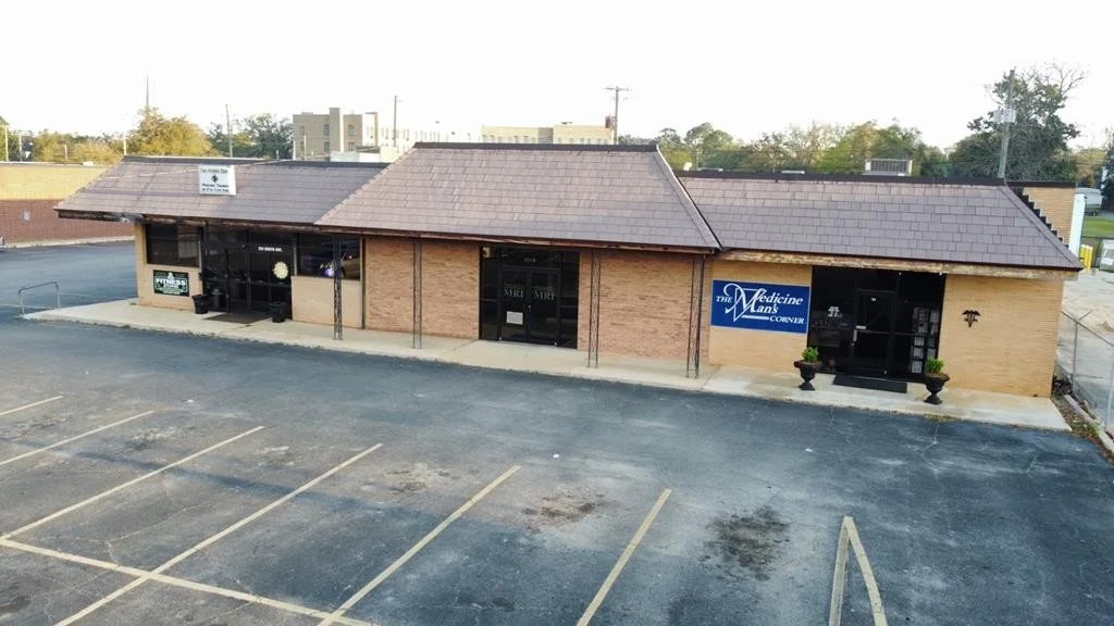 An exterior drone view of The Medicine Man's Corner brick building at 311 Smith Ave.