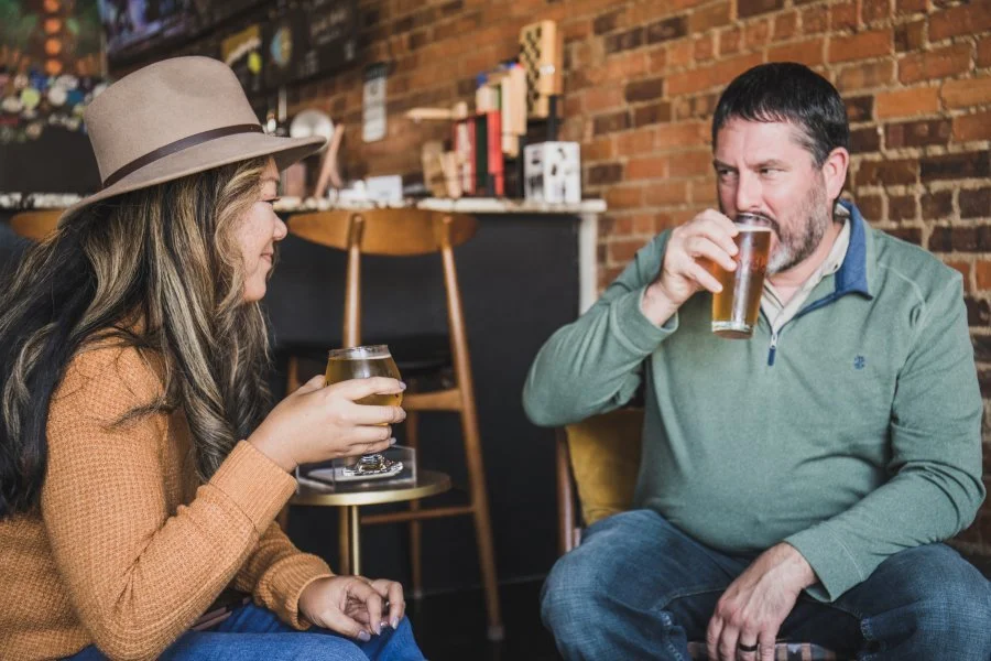  two people enjoying glasses of beer in a cozy bar setting