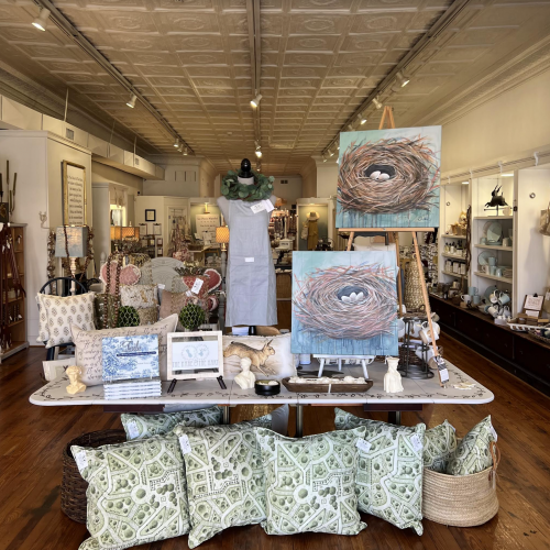 Interior of a vintage store displaying furniture, artwork, and home decor items.