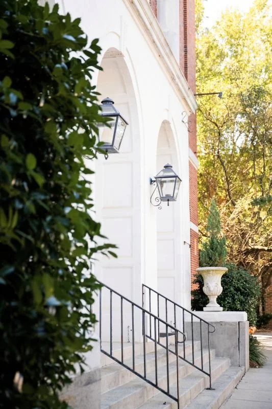 the entrance of a white stucco building with arched doorways