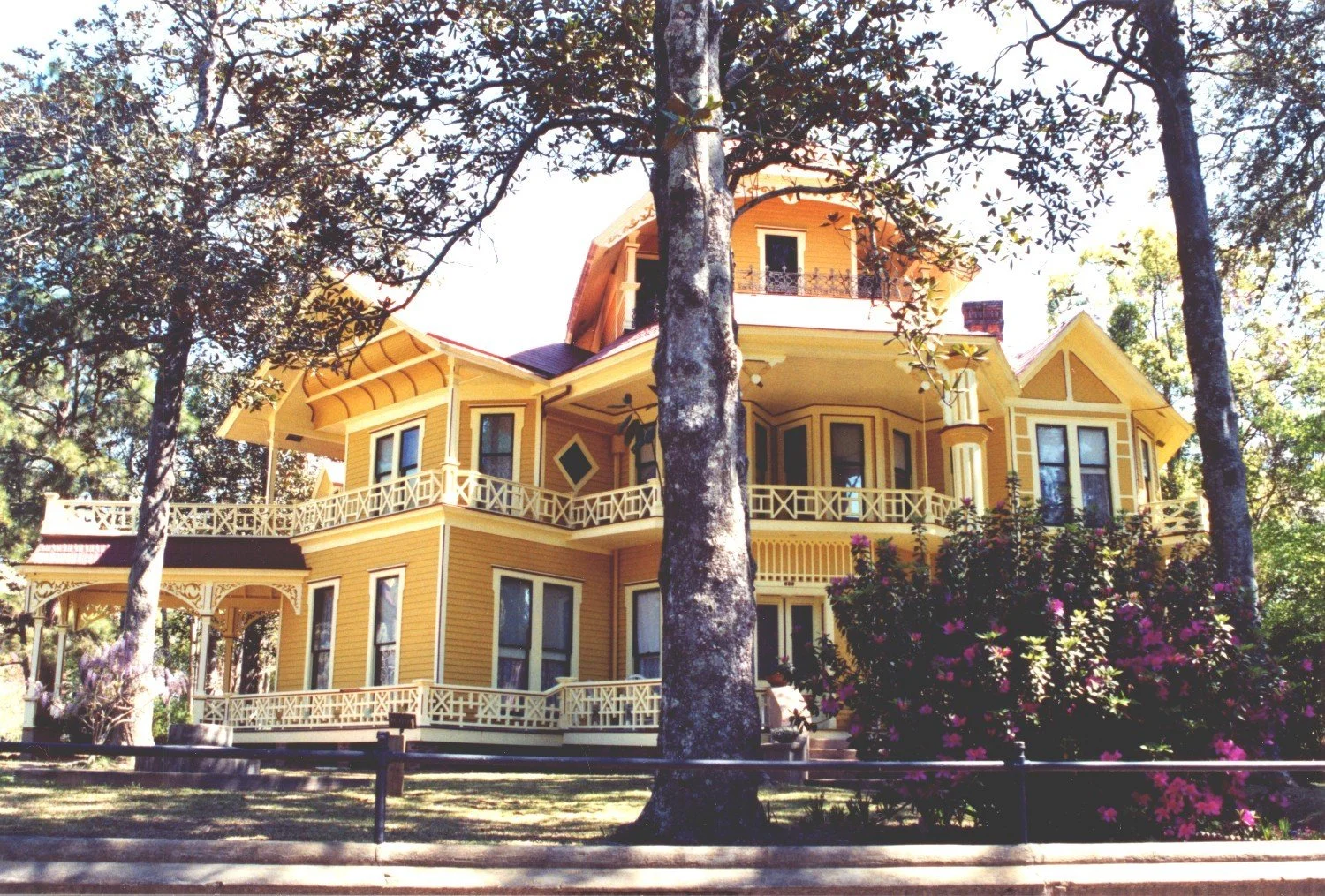Historic yellow Lapham-Patterson House with a wooden sign on lawn