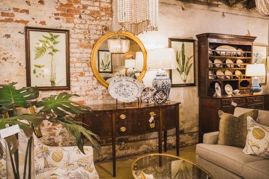 a vintage-style interior featuring antiques and an exposed brick wall