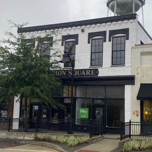 The exterior of Station Square, a white two-story building with black-trimmed windows