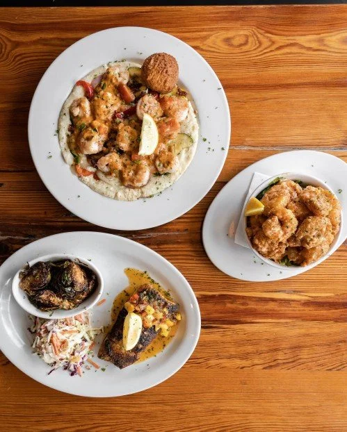 Overhead view of Southern food dishes including shrimp and grits