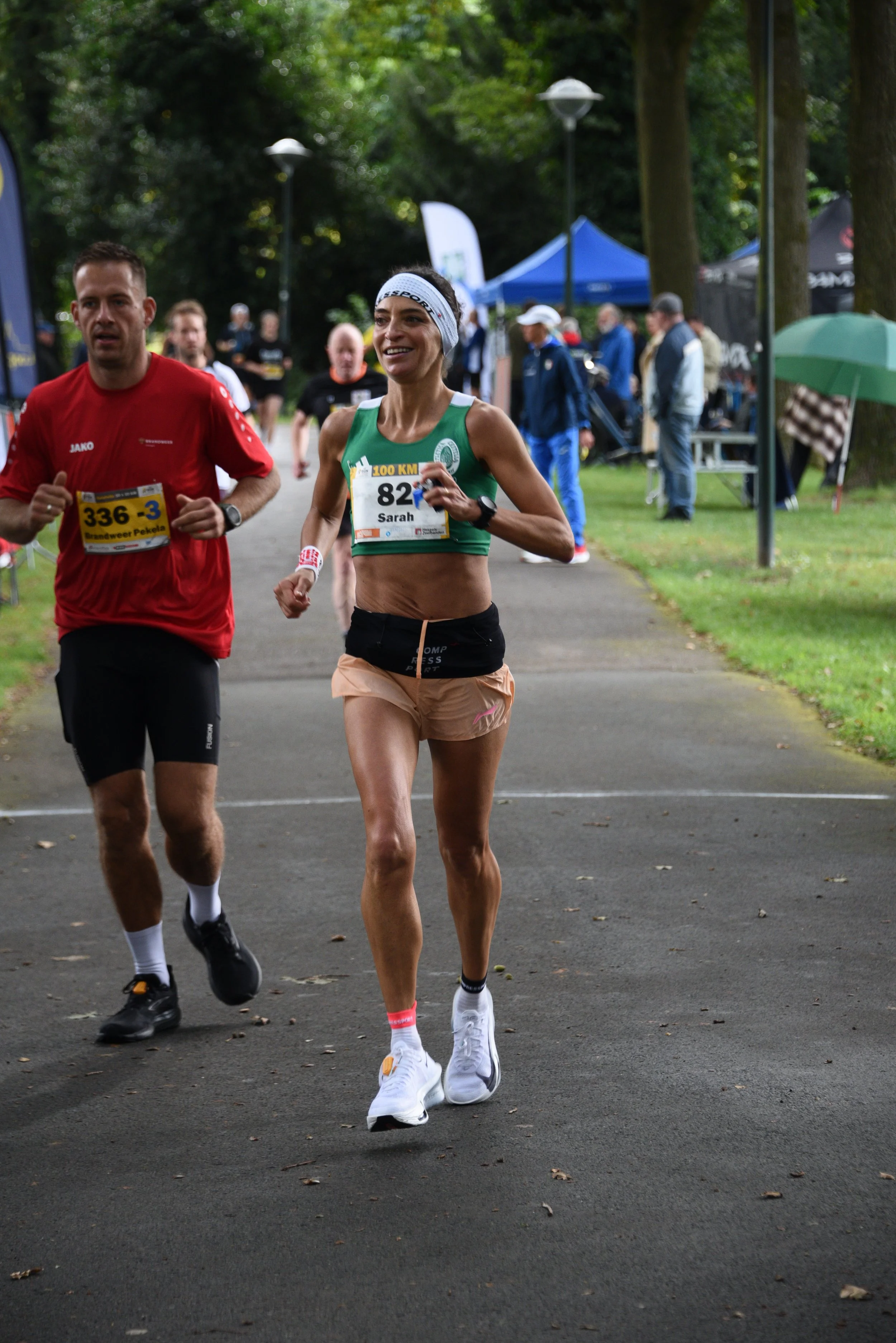 Due corridori partecipano a una gara in un parco, uno di loro è una donna con pettorale 82 e l'altro un uomo con pettorale 336.