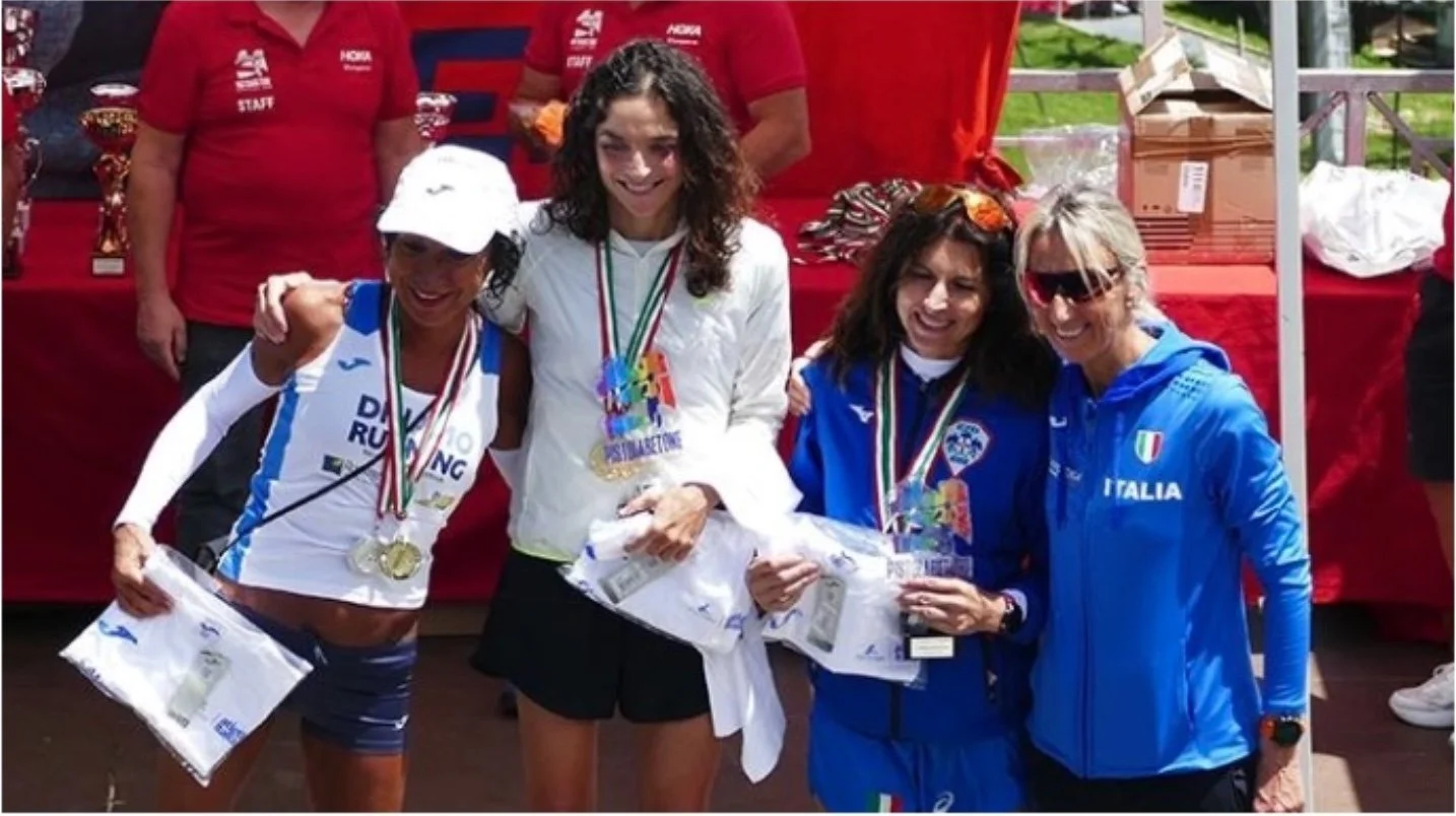 Atlete femminili sul podio con medaglie d'oro, d'argento e di bronzo, celebrando una vittoria durante una competizione.