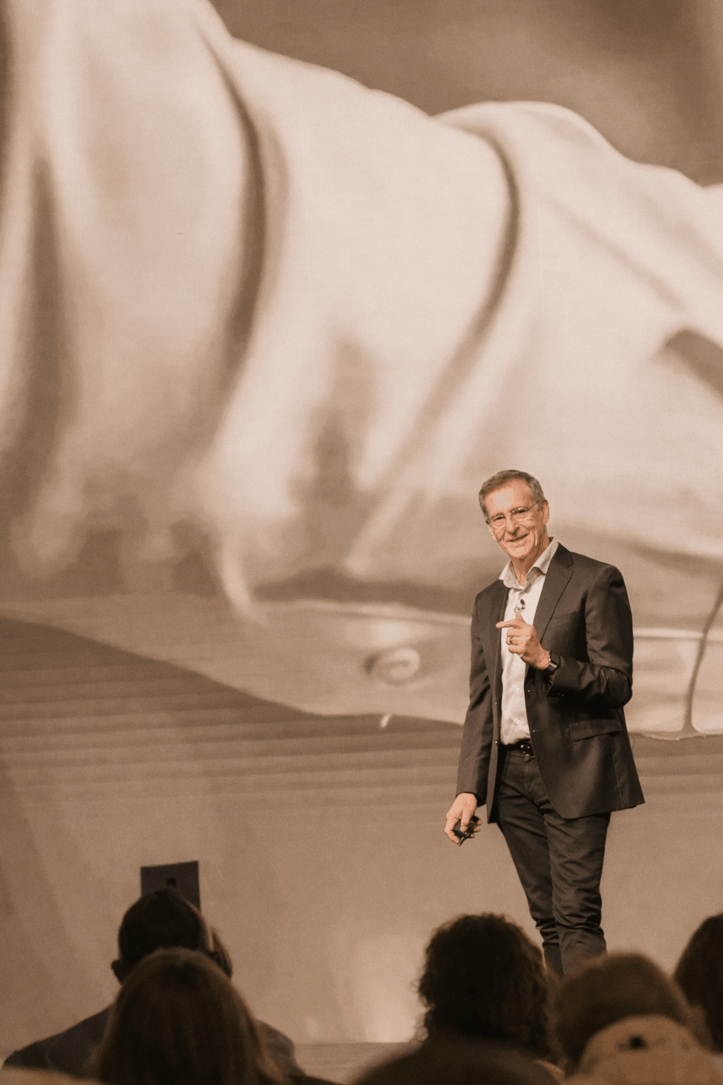 Gregory Sampson of Masen Strategies giving a talk on a stage with an audience