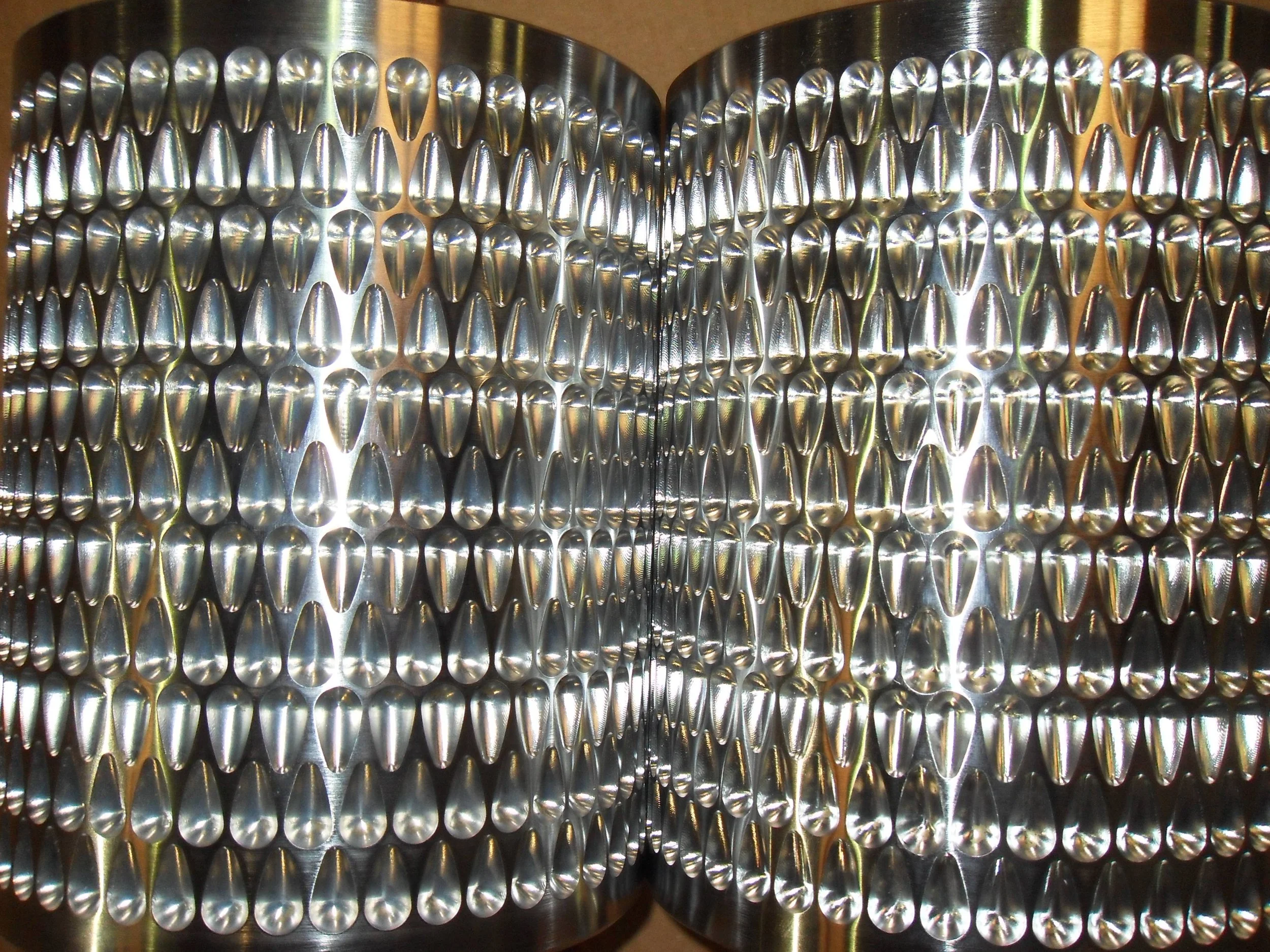 Two stacks of aluminum cans arranged in a pattern, with the cans turned upside down and tightly packed together.