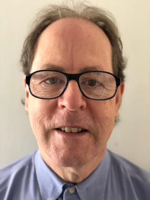 Steve Marshall, Close-up of a middle-aged man with glasses and gray hair, wearing a blue collared shirt, smiling slightly against a neutral background.