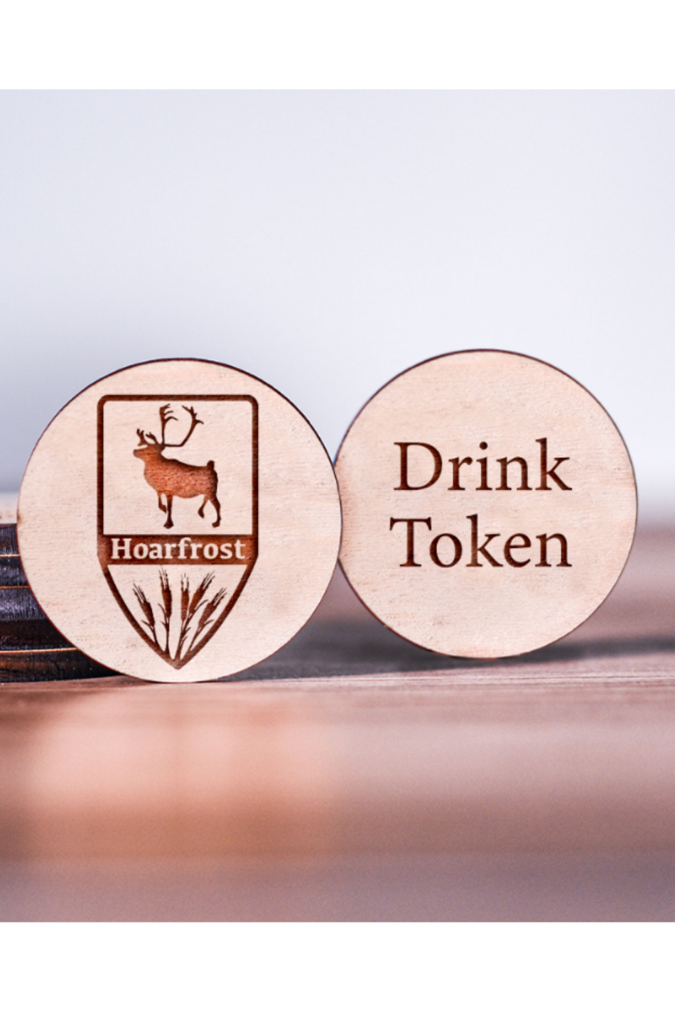 Wooden tokens with a logo of a deer and wheat on one token and the text 'Drink Token' on the other token.