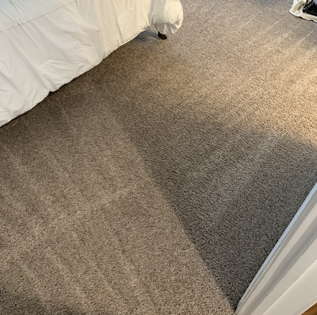 Different shades of brown carpet in a bedroom with a white bedspread. The carpet appears clean and well-maintained.
