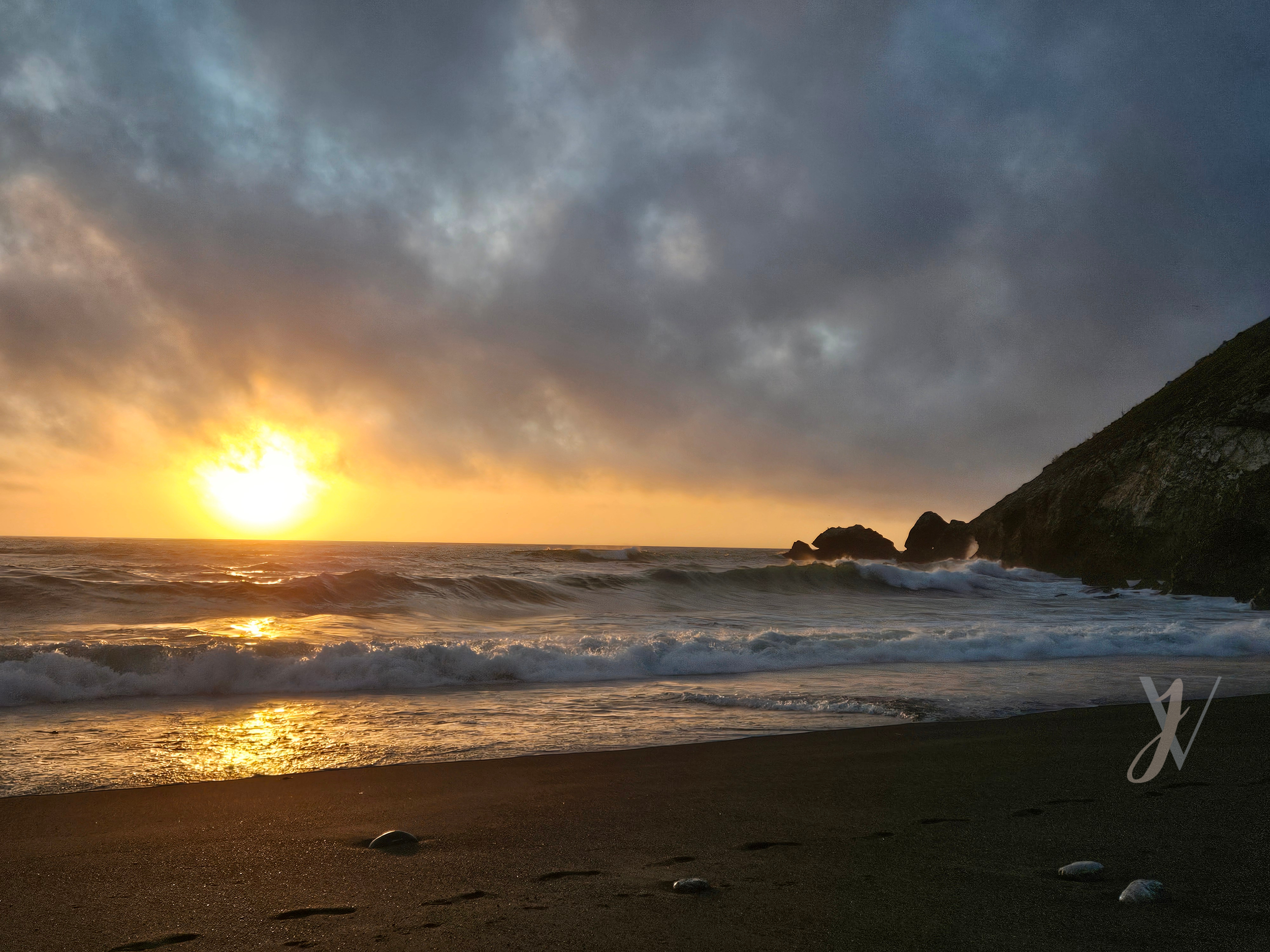 sunset on the beach, ocean waves crashing against the rocks