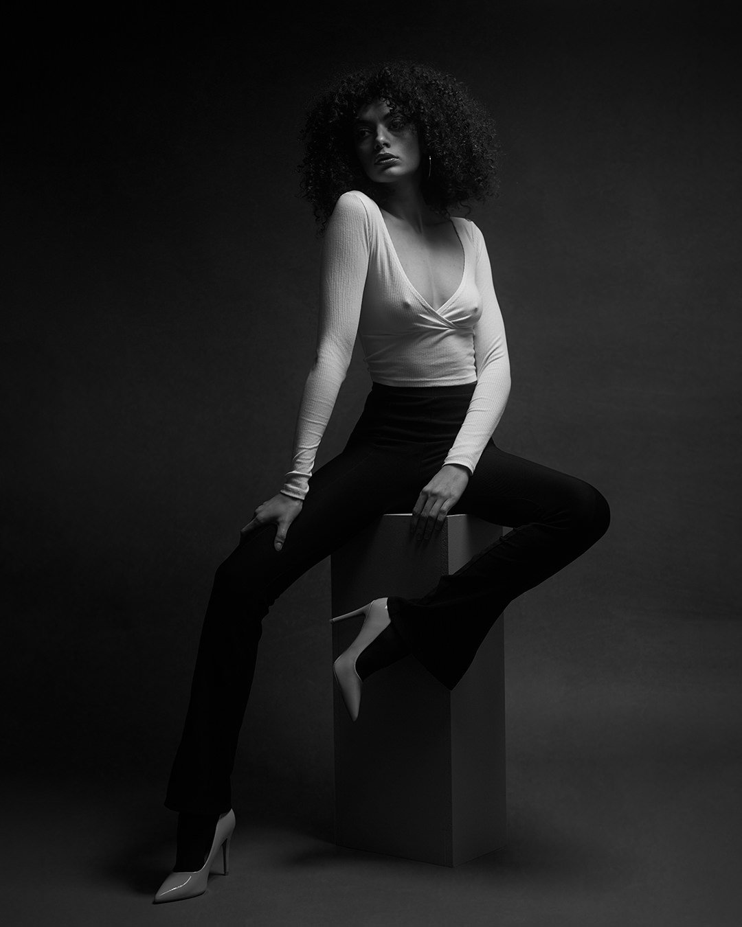 Portret fashion alb-negru realizat în studio, cu lumină dramatică și estetică minimalistă. Fotografie artistică ce surprinde forță, expresivitate și rafinament.