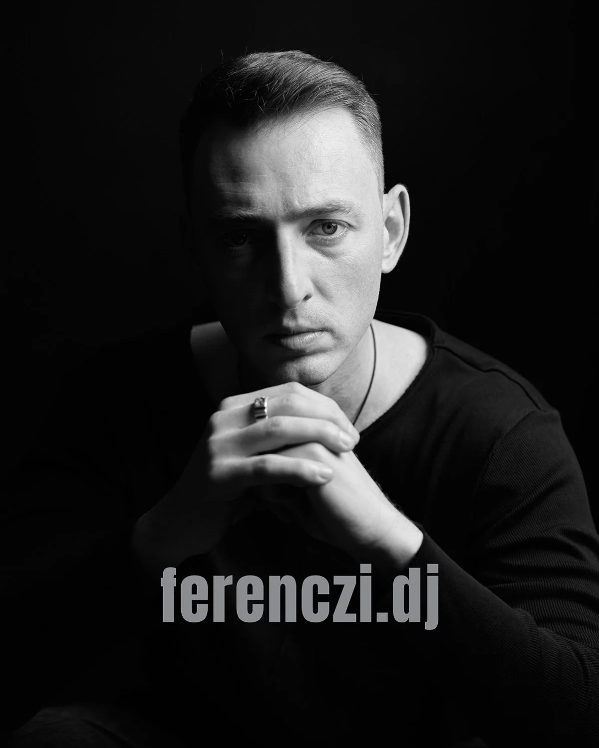 Portret alb-negru al unui tânăr cu părul scurt, privind direct la cameră cu o expresie serioasă, cu bărbia sprijinită în mână, cu textul „ferenczi.dj” în partea de jos.