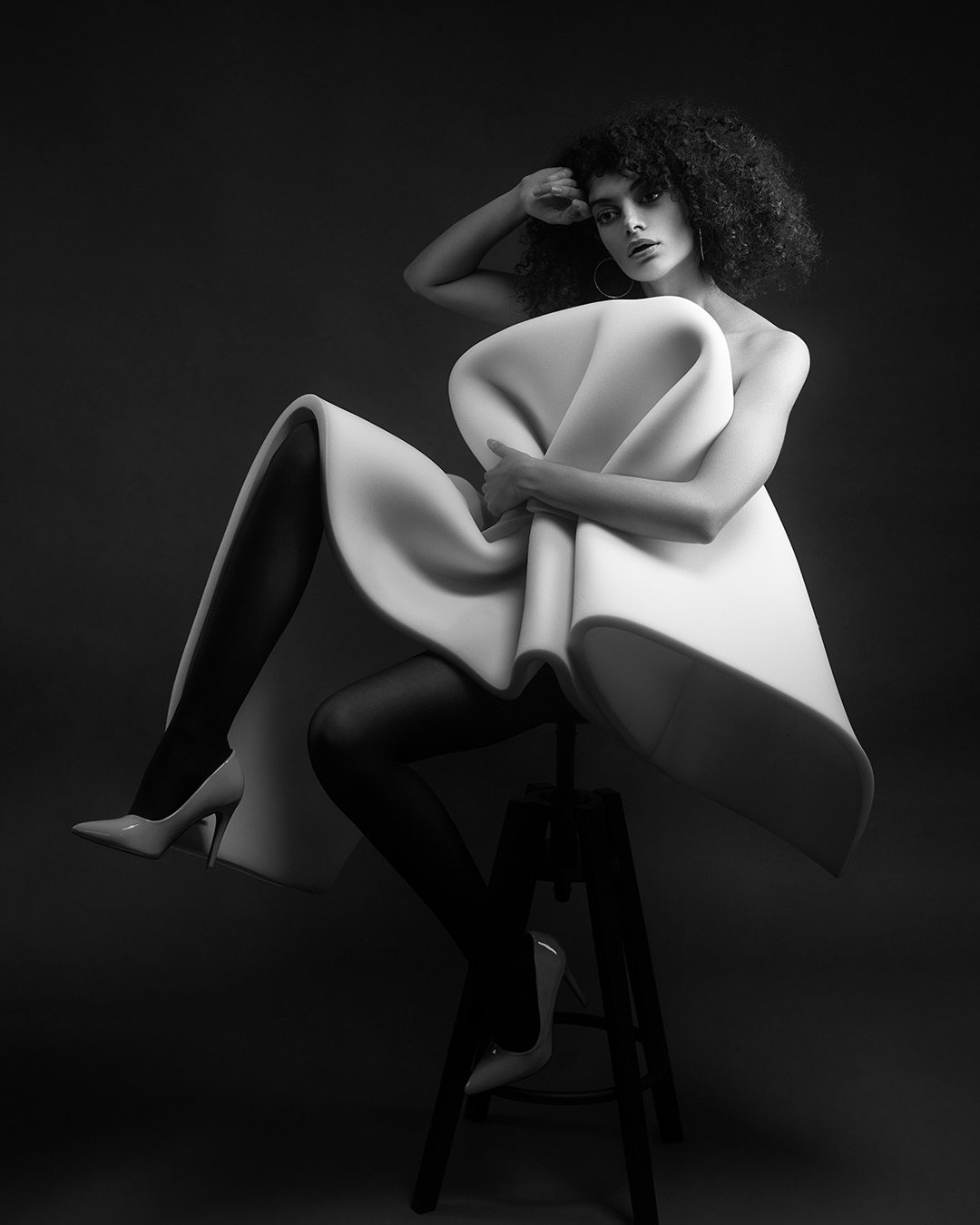 Portret fashion alb-negru realizat în studio, cu lumină dramatică și estetică minimalistă. Fotografie artistică ce surprinde forță, expresivitate și rafinament.