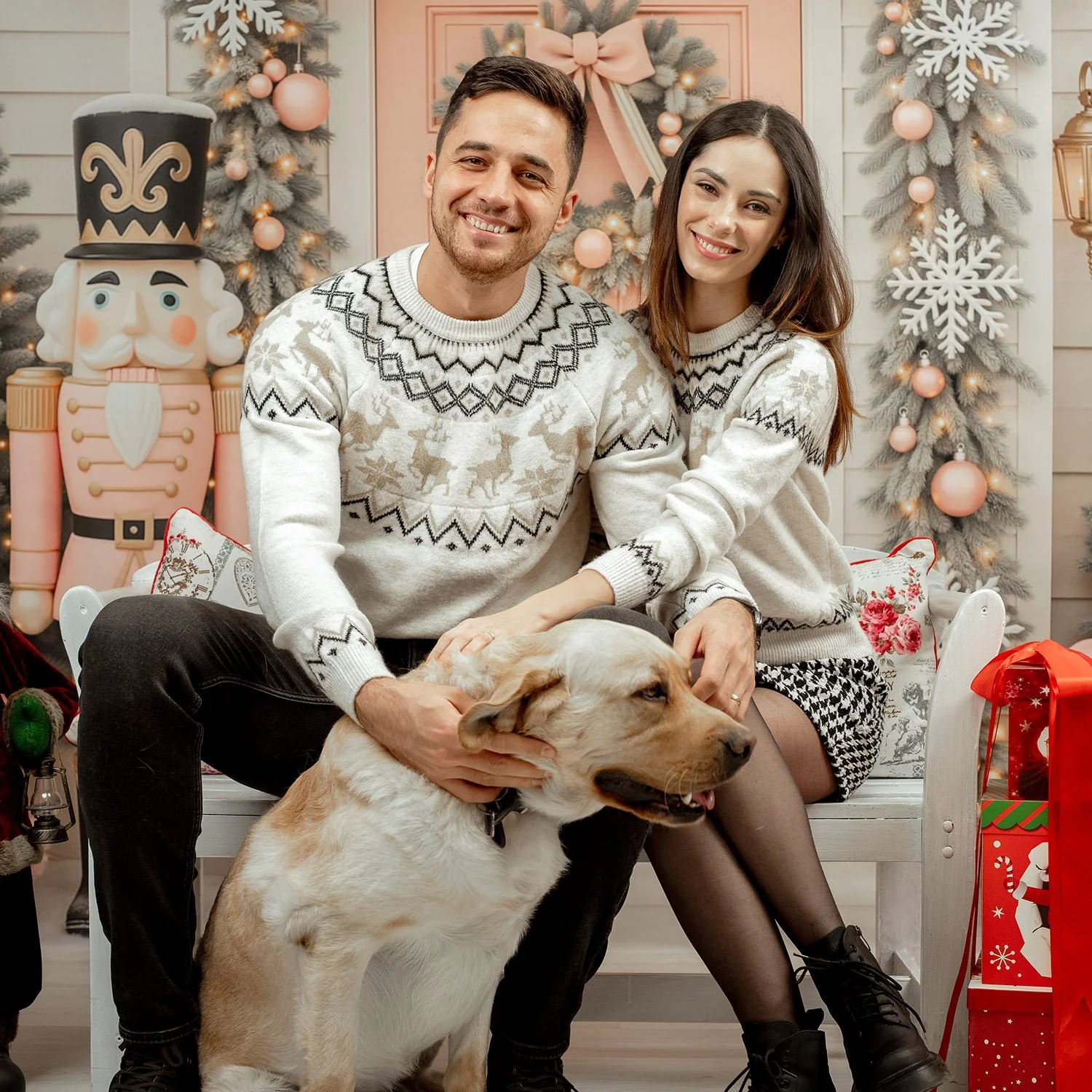 Familie zâmbitoare  și un câine Golden Retriever într-un studio foto din Târgu Mureș decorat festiv pentru ședința de Crăciun.