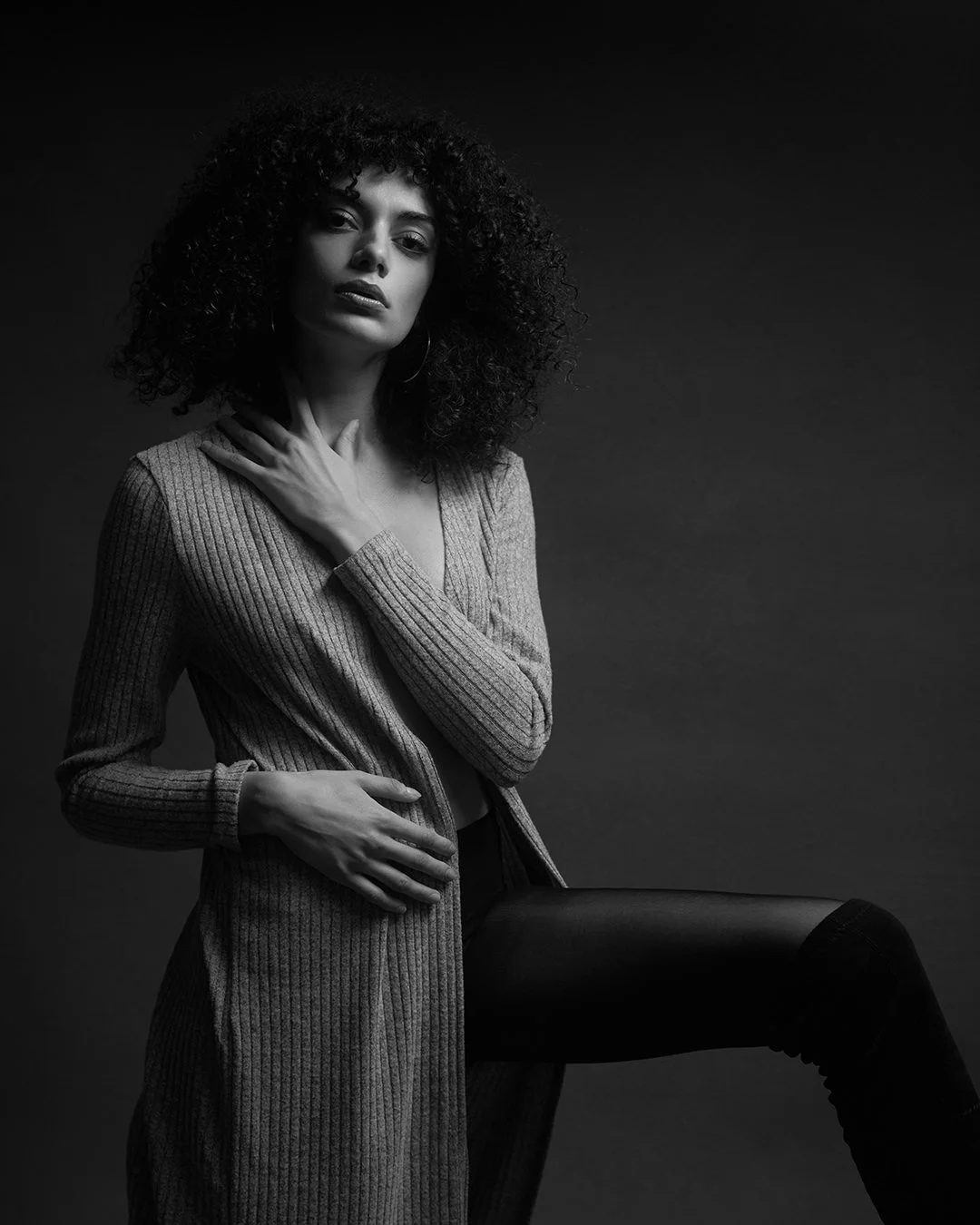 Portret fashion alb-negru realizat în studio, cu lumină dramatică și estetică minimalistă. Fotografie artistică ce surprinde forță, expresivitate și rafinament.