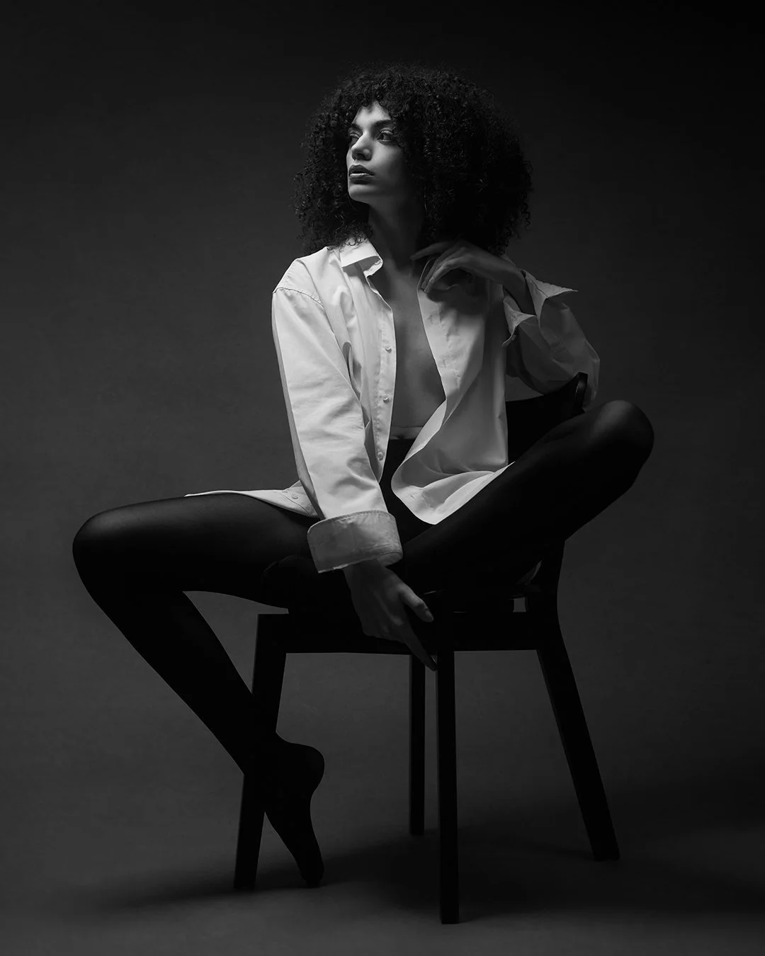 Portret fashion alb-negru realizat în studio, cu lumină dramatică și estetică minimalistă. Fotografie artistică ce surprinde forță, expresivitate și rafinament.