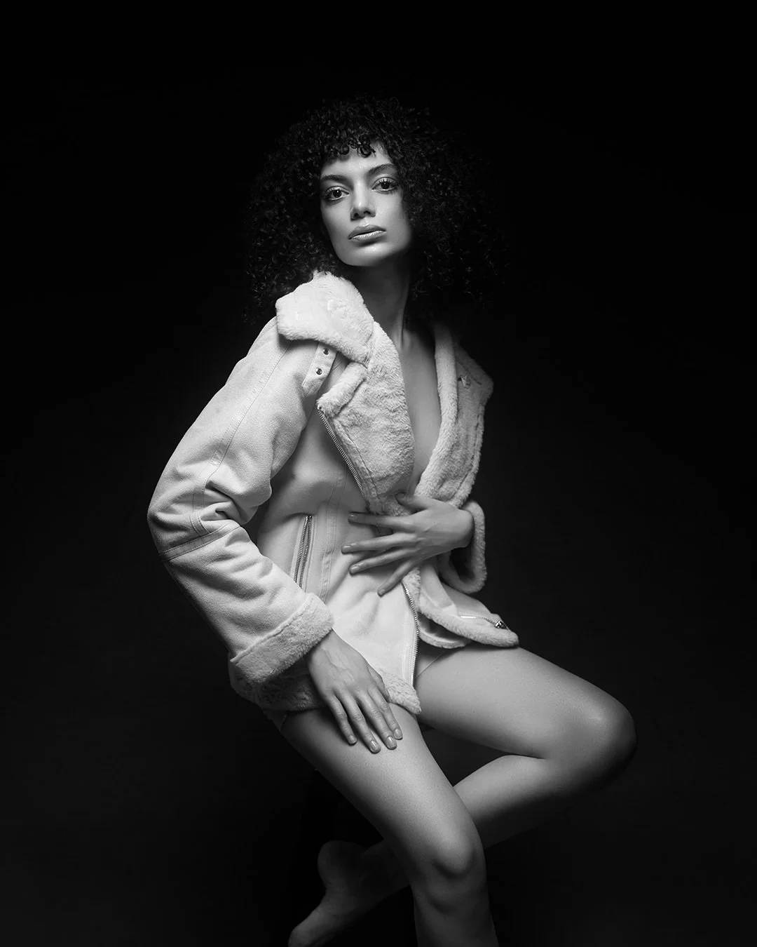 Portret fashion alb-negru realizat în studio, cu lumină dramatică și estetică minimalistă. Fotografie artistică ce surprinde forță, expresivitate și rafinament.