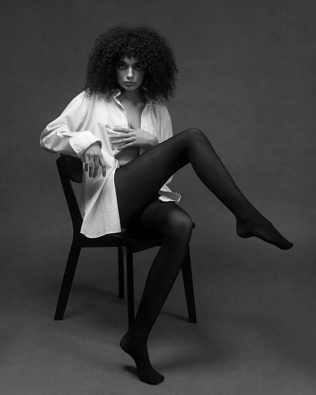 Portret fashion alb-negru realizat în studio, cu lumină dramatică și estetică minimalistă. Fotografie artistică ce surprinde forță, expresivitate și rafinament.