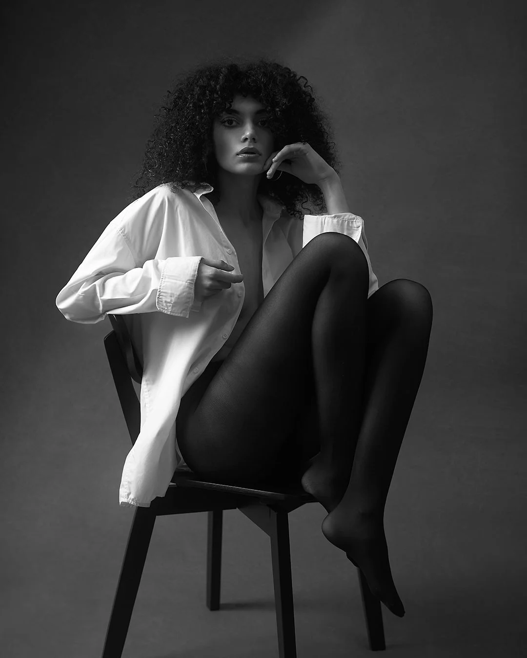 Portret fashion alb-negru realizat în studio, cu lumină dramatică și estetică minimalistă. Fotografie artistică ce surprinde forță, expresivitate și rafinament.