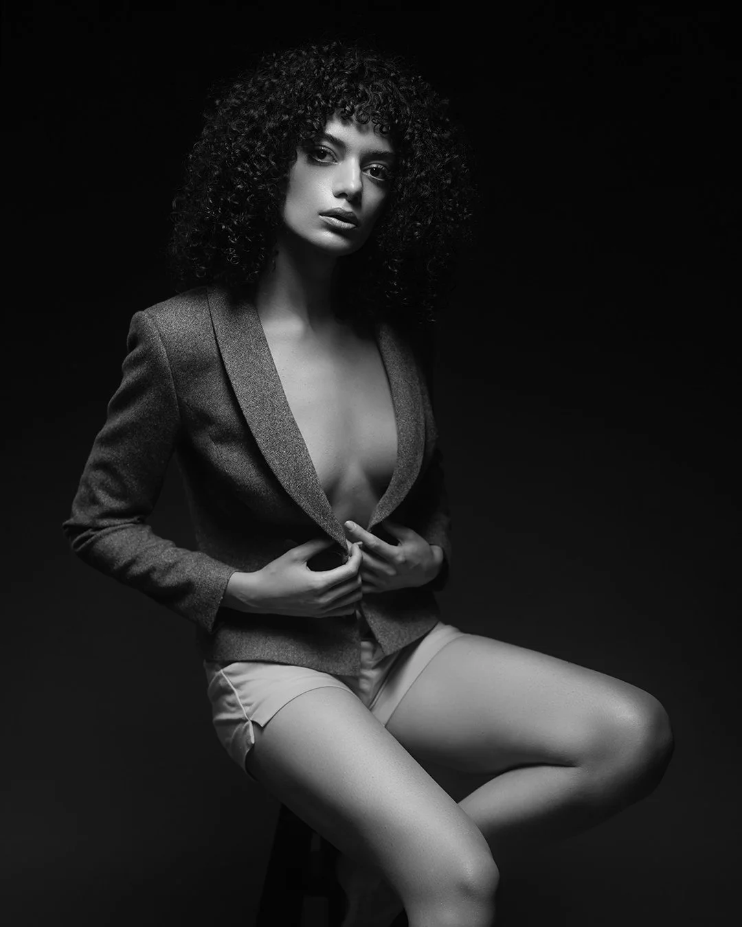 Portret fashion alb-negru realizat în studio, cu lumină dramatică și estetică minimalistă. Fotografie artistică ce surprinde forță, expresivitate și rafinament.