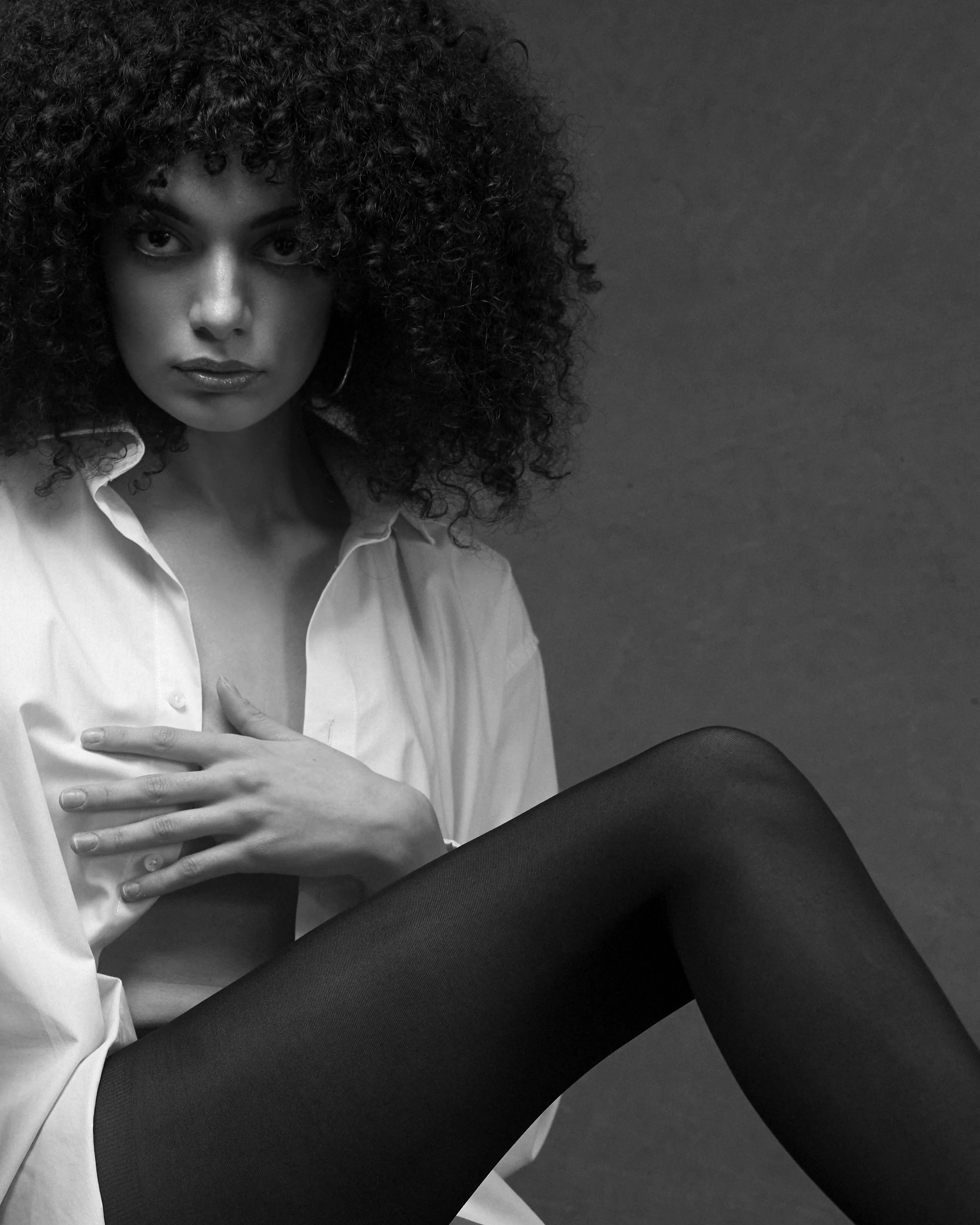 Portret fashion alb-negru realizat în studio, cu lumină dramatică și estetică minimalistă. Fotografie artistică ce surprinde forță, expresivitate și rafinament.