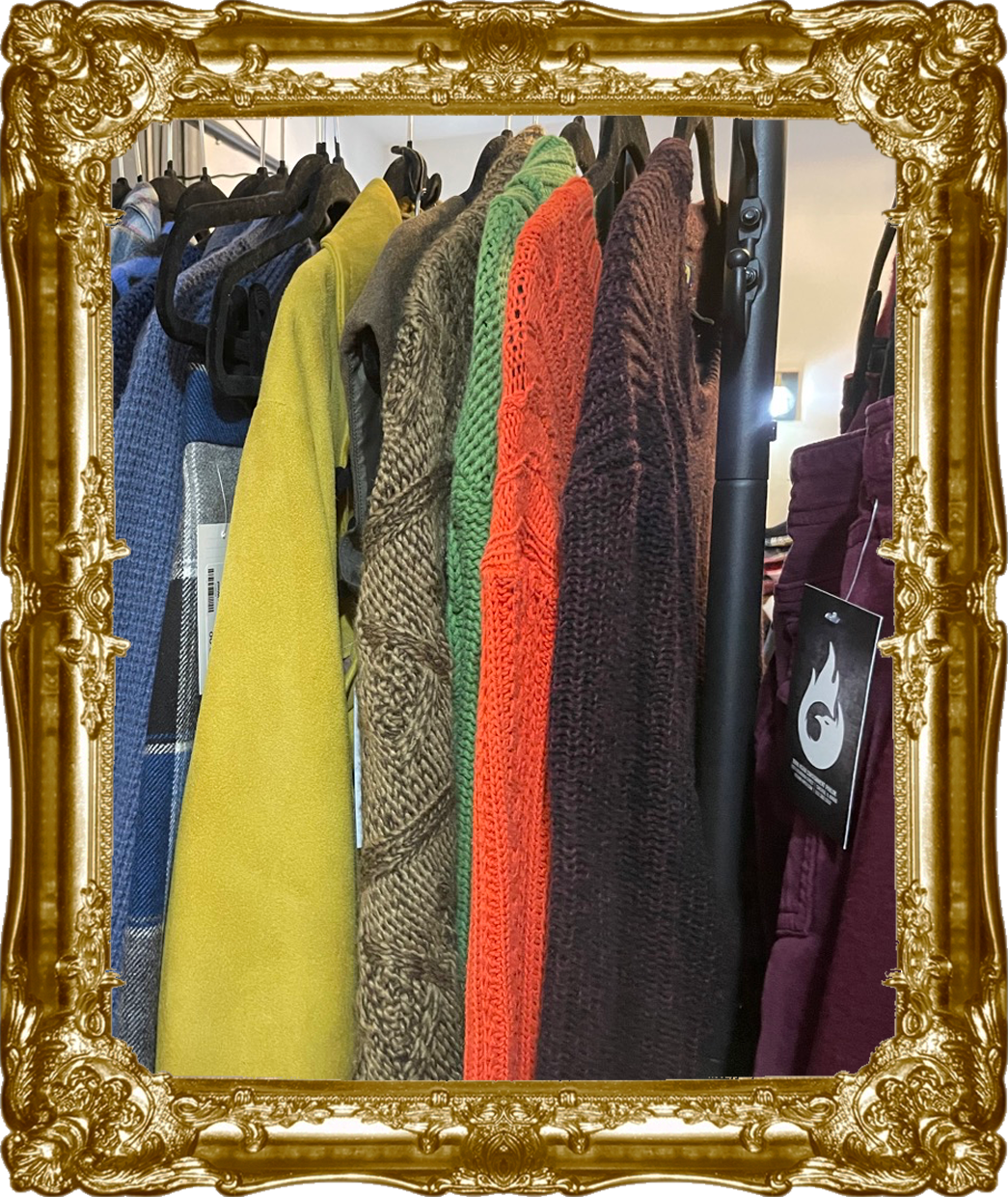 Born Again Consignment Parlor. Printers Row. Clothing rack with colorful coats and jackets in various fabrics and textures, displayed on black hangers.