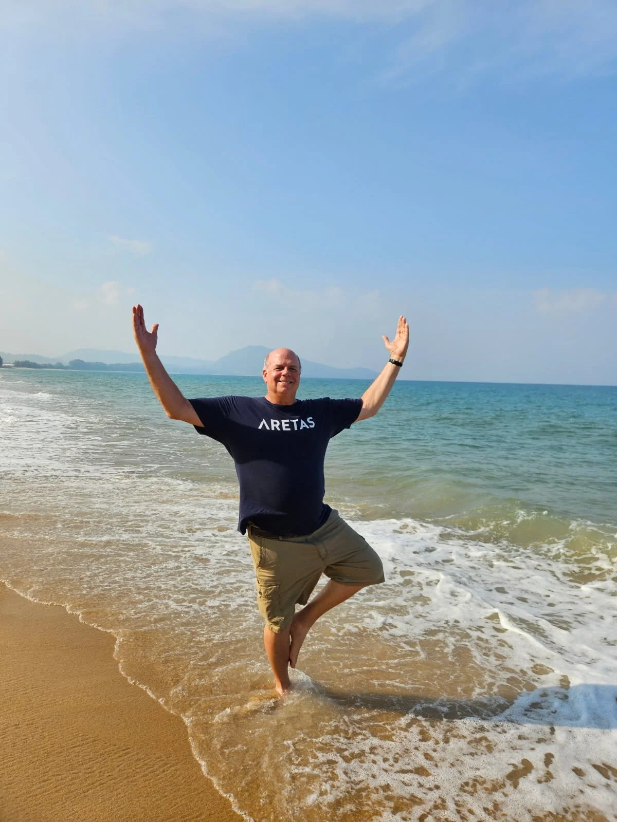 man in aretas shirt on beach