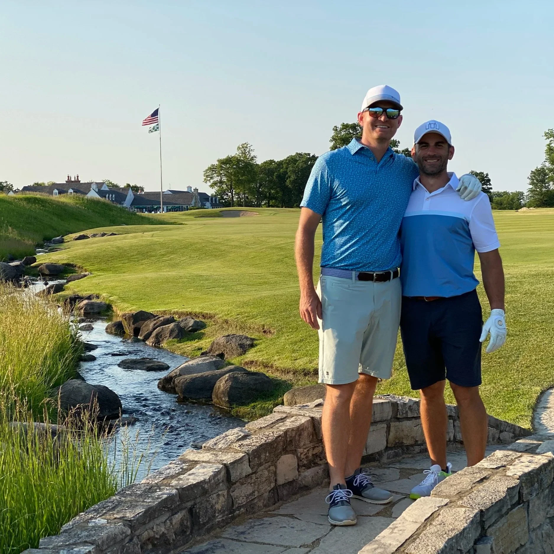 The owners of Aretas Physical Therapy on the golf course in front of a flag