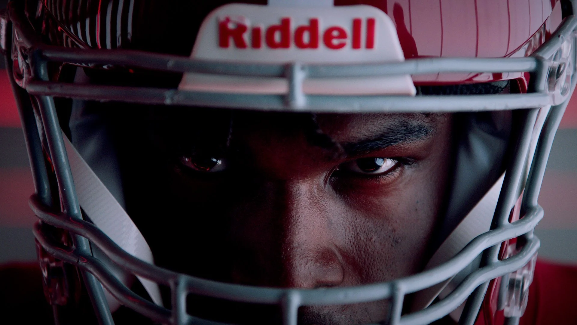 Close-up of an American football player wearing a helmet with a focused expression.