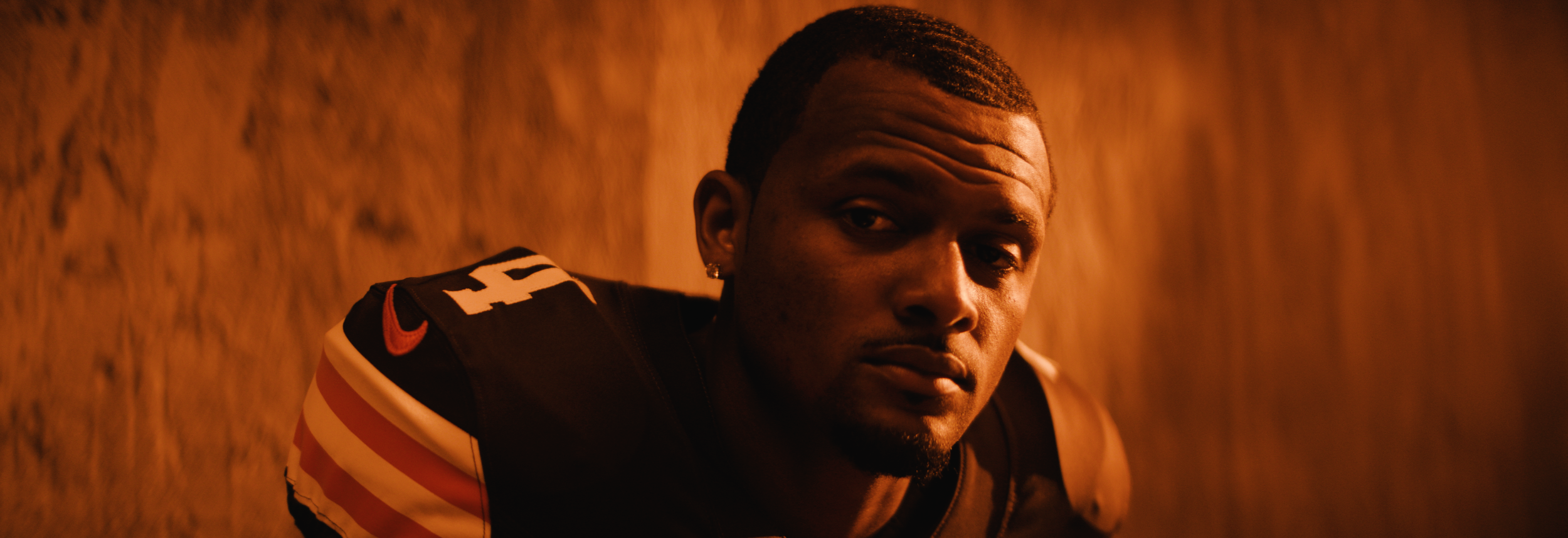 Close-up of a football player in uniform with orange lighting.  Cleveland Browns. Sports director of photography camera operator. Arri Alexa 35 anamorphics.