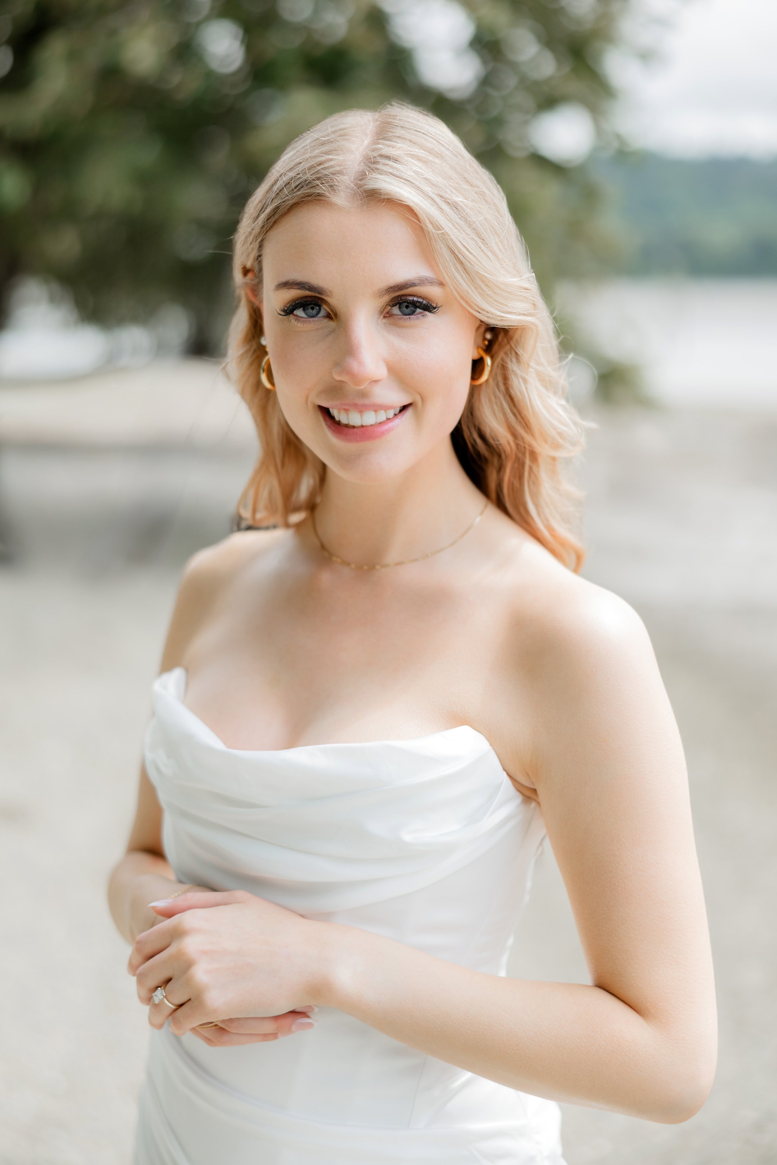 Bride smiling at the beach in soft natural light