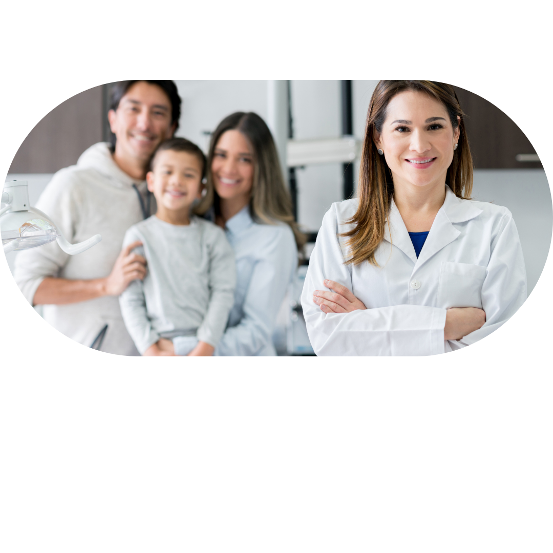A female healthcare professional standing with crossed arms and smiling in foreground, with a happy family of four, including a father, mother, and young boy, in the background in a medical or dental office.  healthcare. family doctor. family nurse