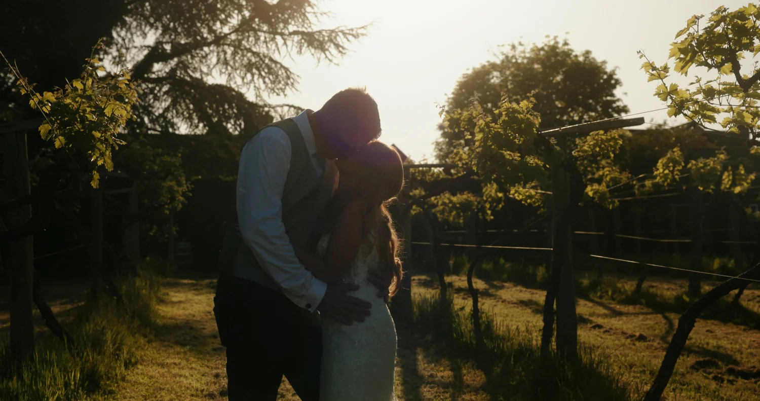Carli and Neil sharing a sunset moment among the vines at Old Luxters Barn