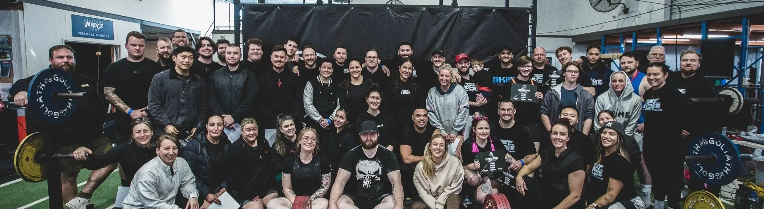 Large group of people together with a deadlift platform in front of them after a novice powerlifting competition