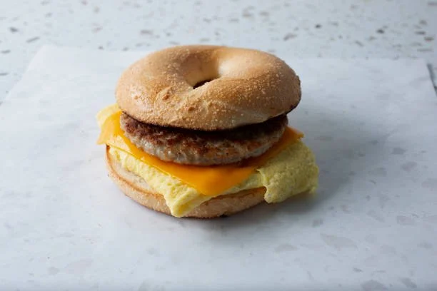 Bagel sandwich with sausage patty, scrambled egg, and cheese.