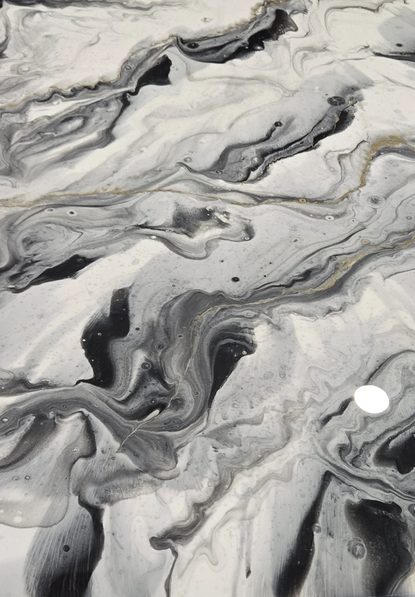 Abstract black, white, and gray metallic epoxy floor with swirling lines and textures.