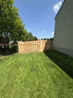 Custom backyard fence featuring a walk-through gate for easy access and a larger equipment gate (front)