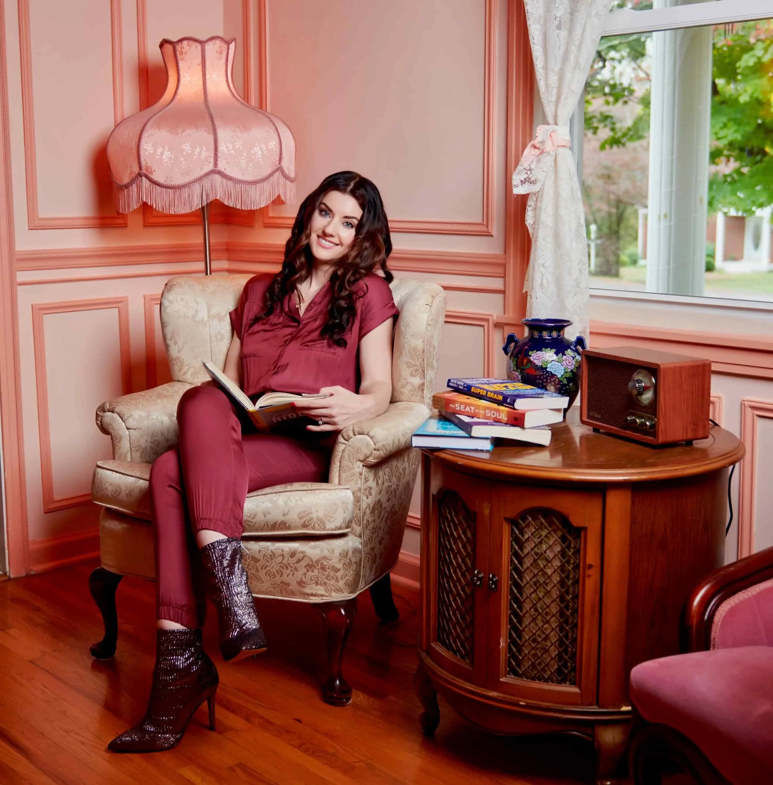 Therapist seated next to a stack of empowering books in an uplifting setting