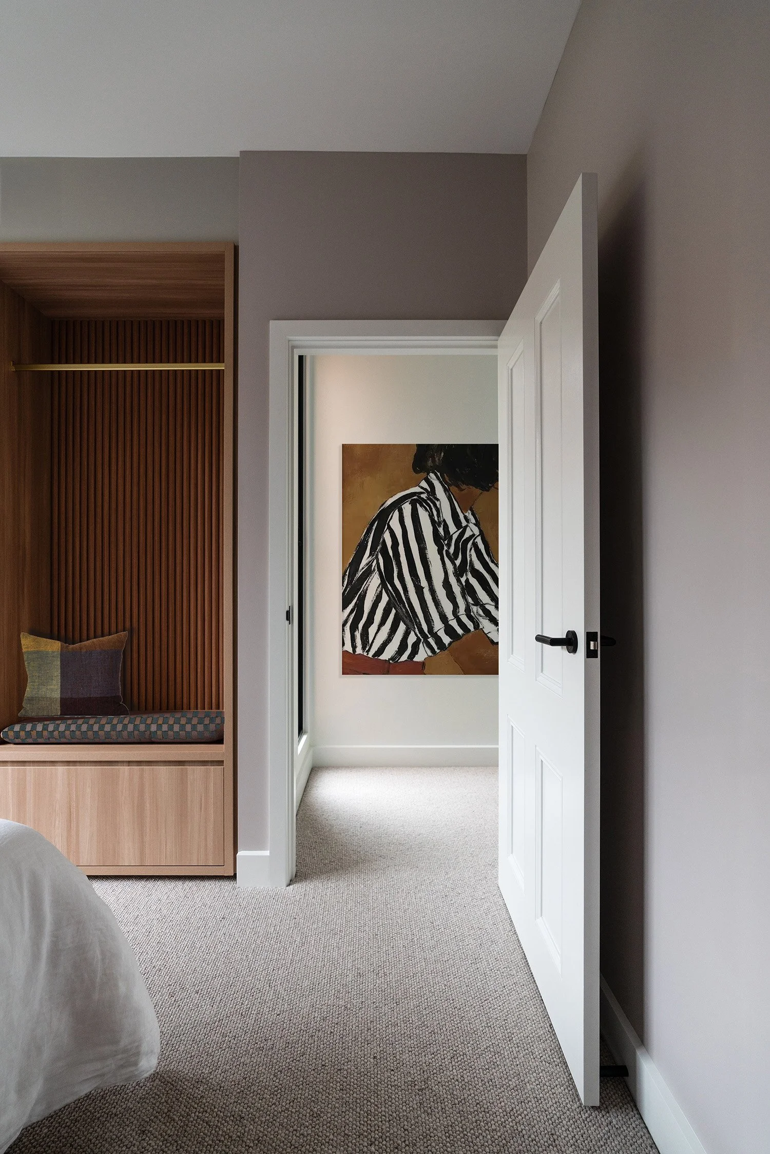 Horizon House Prahran home interior featuring soft neutral walls, timber joinery, built-in window seat and framed artwork through adjoining room