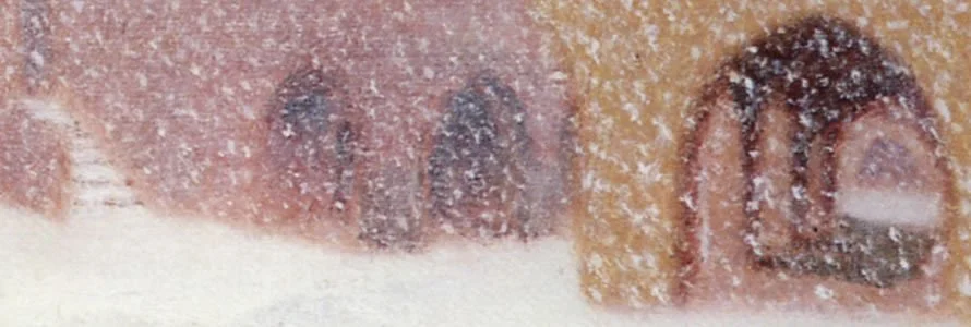 Close-up of a surface with snow or frost, revealing part of a printed or stamped design in red and black ink.